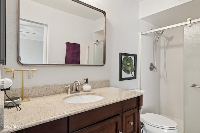 bathroom with vanity, crown molding, a shower with shower door, and toilet