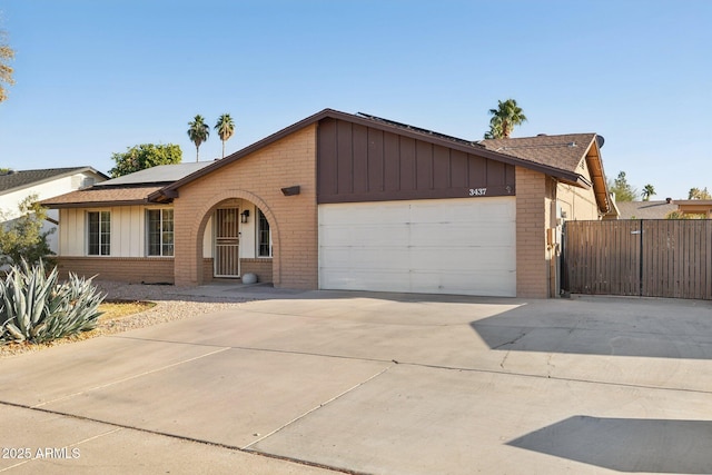 ranch-style house featuring a garage and solar panels