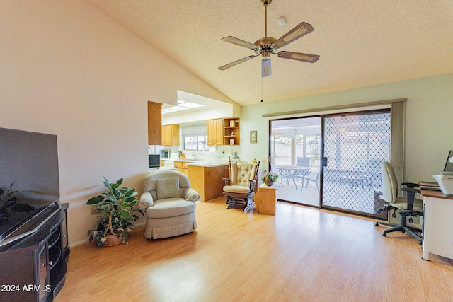 interior space featuring ceiling fan, light hardwood / wood-style flooring, high vaulted ceiling, and sink