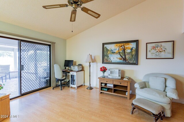 dining space with high vaulted ceiling, ceiling fan with notable chandelier, and hardwood / wood-style floors