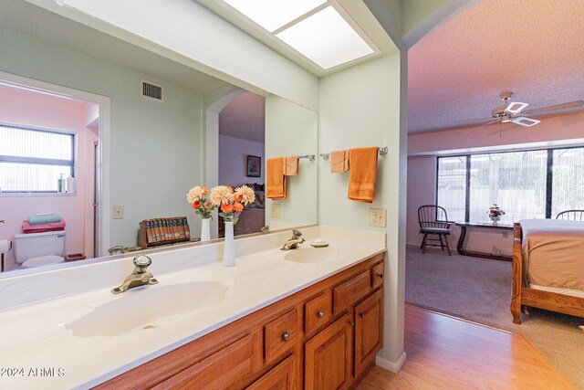 bathroom featuring dual bowl vanity and hardwood / wood-style floors