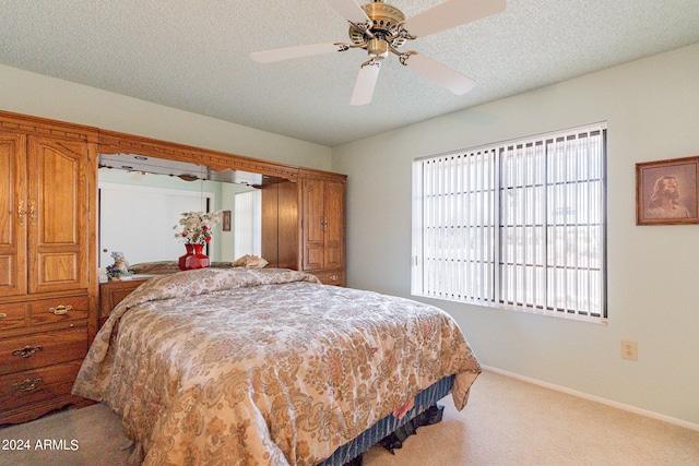 carpeted bedroom with ceiling fan and a textured ceiling