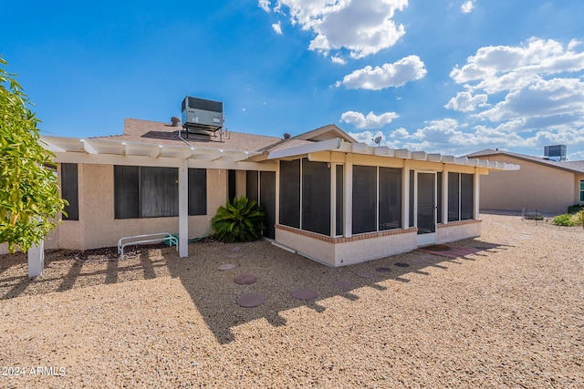 rear view of property featuring central AC, a sunroom, and a pergola