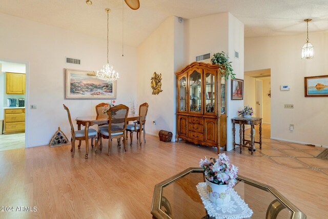 living room with light hardwood / wood-style flooring, ceiling fan, and high vaulted ceiling