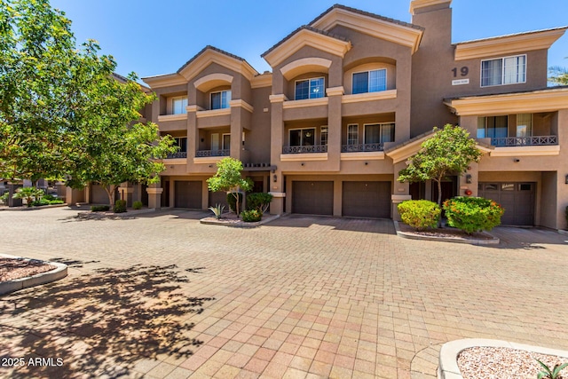 4465 E Paradise Village Pkwy S Unit 1224, Phoenix, AZ 85032 - view of front of house featuring a garage, stucco siding, driveway, and a chimney