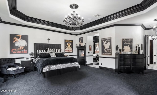 carpeted bedroom featuring a tray ceiling, a notable chandelier, visible vents, arched walkways, and ornamental molding
