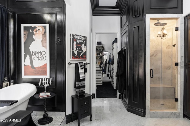 full bath featuring a stall shower, a freestanding tub, a spacious closet, marble finish floor, and ornamental molding