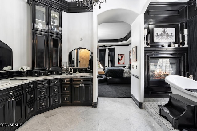 bathroom with a freestanding bath, double vanity, crown molding, and connected bathroom