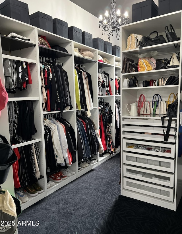 walk in closet with an inviting chandelier and carpet floors