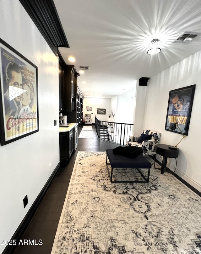 living area featuring dark wood-style flooring, baseboards, and visible vents