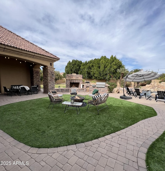 view of yard with an outdoor living space with a fireplace and a patio area