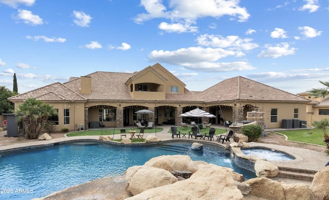 view of swimming pool featuring a pool with connected hot tub and a patio