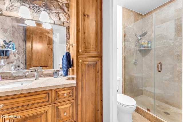 full bathroom with a stall shower, toilet, and vanity