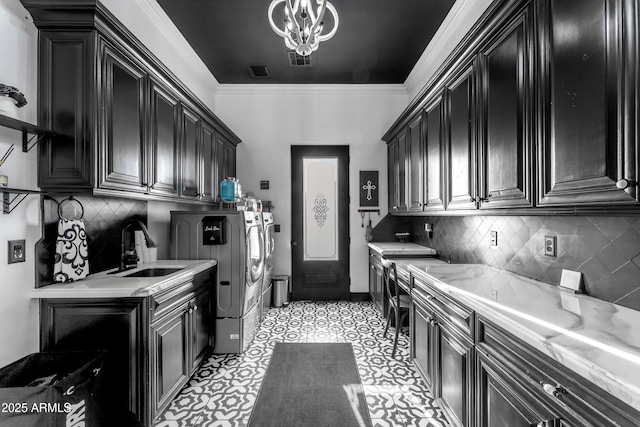 clothes washing area with ornamental molding, separate washer and dryer, a sink, visible vents, and cabinet space