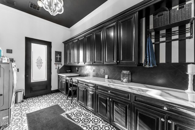kitchen with visible vents, crown molding, light stone countertops, dark cabinets, and backsplash