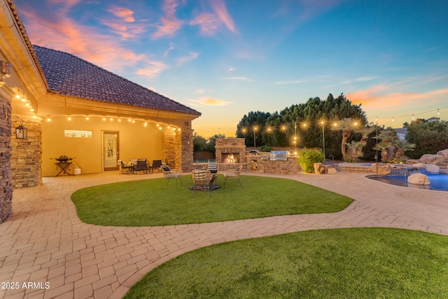 exterior space with area for grilling, a grill, an outdoor stone fireplace, and an outdoor pool