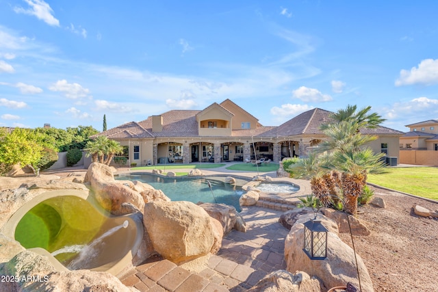pool featuring an in ground hot tub, a patio, and a yard