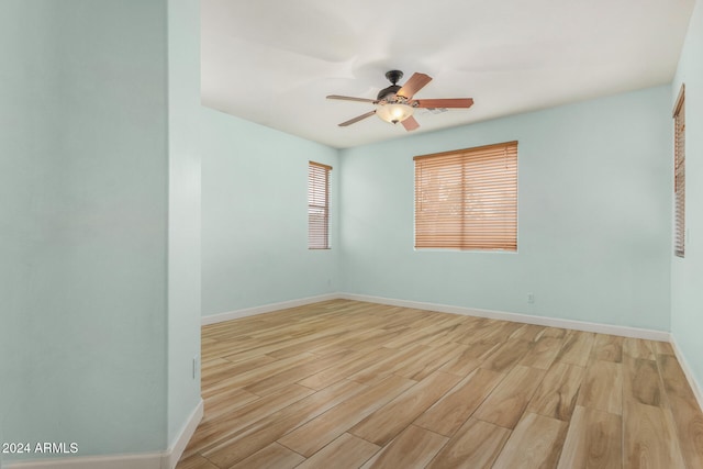 spare room with light wood-type flooring and ceiling fan