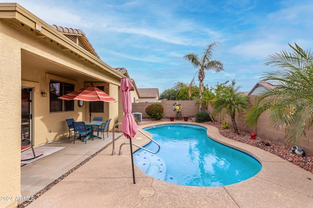 view of pool featuring central air condition unit and a patio