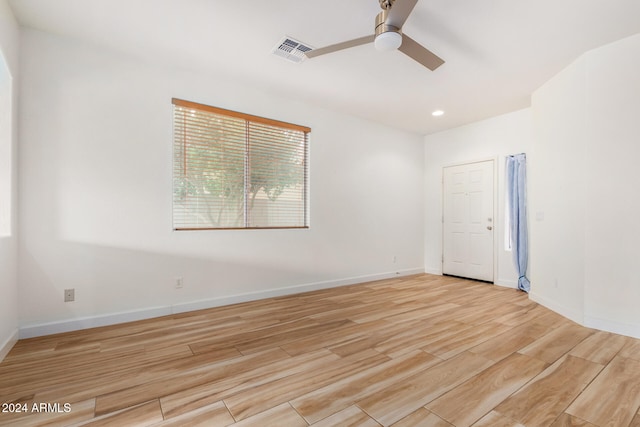 spare room with light wood-type flooring and ceiling fan