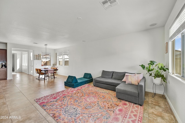 living room with a notable chandelier, plenty of natural light, and light tile patterned floors