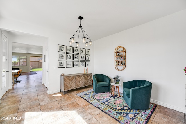 sitting room featuring light tile patterned flooring and a notable chandelier