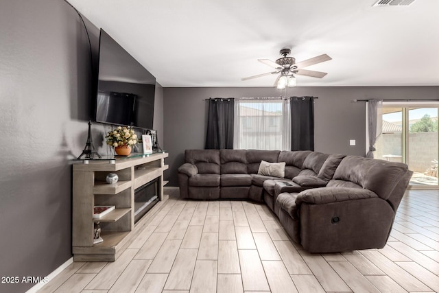 25539 W Gwen St, Buckeye, AZ 85326 - living room with light wood-style flooring, ceiling fan, and baseboards