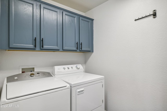 washroom with cabinets and washer and dryer