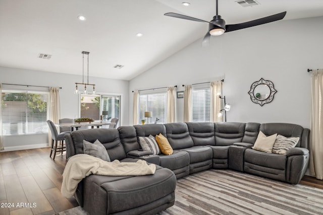 living room featuring light hardwood / wood-style flooring, high vaulted ceiling, ceiling fan, and plenty of natural light