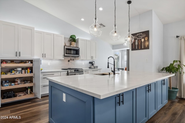 kitchen with light stone counters, appliances with stainless steel finishes, hanging light fixtures, white cabinets, and dark wood-type flooring