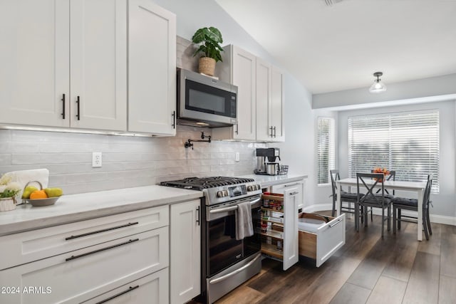 kitchen featuring stainless steel appliances, dark wood-type flooring, lofted ceiling, backsplash, and white cabinetry