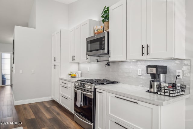 kitchen featuring white cabinetry, light stone counters, appliances with stainless steel finishes, tasteful backsplash, and dark hardwood / wood-style floors