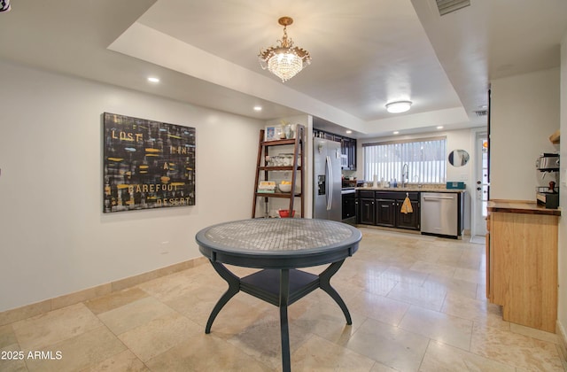 dining room featuring an inviting chandelier and a raised ceiling