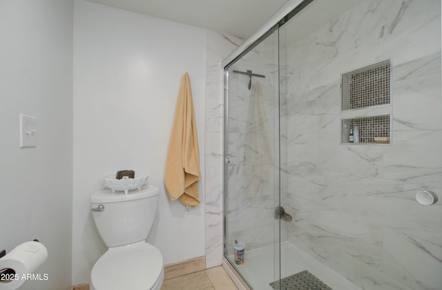 bathroom with a shower with shower door and toilet