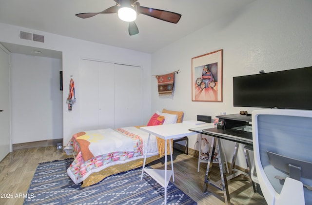 bedroom with hardwood / wood-style flooring, ceiling fan, and a closet