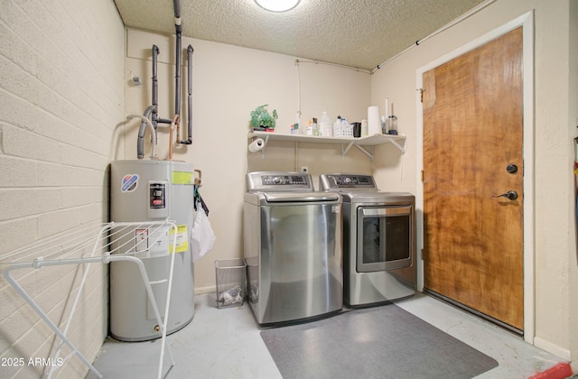 laundry room featuring washing machine and clothes dryer, electric water heater, and a textured ceiling