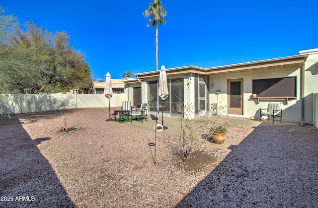 rear view of property with a sunroom and a patio