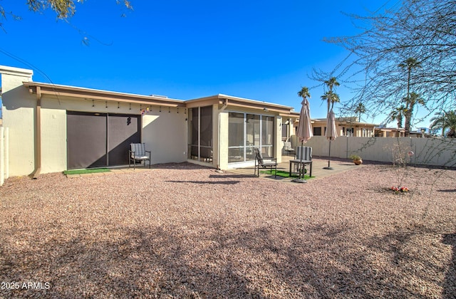 back of property with a patio and a sunroom