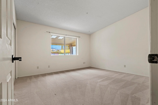 carpeted spare room featuring a textured ceiling