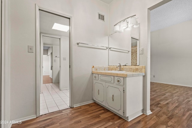 bathroom with vanity, a textured ceiling, and hardwood / wood-style flooring