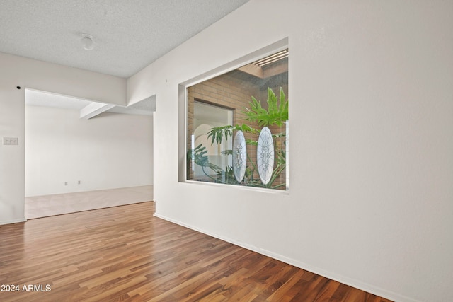 spare room with wood-type flooring and a textured ceiling