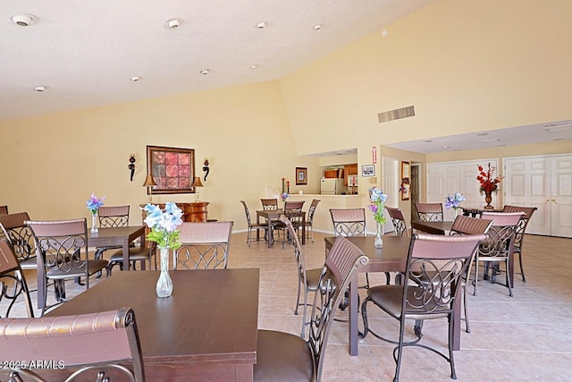 tiled dining space with high vaulted ceiling