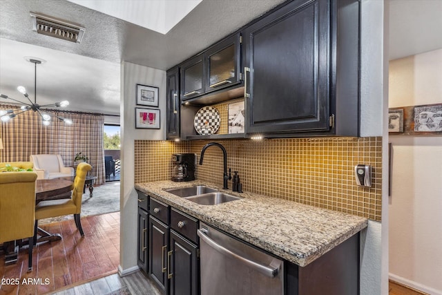 kitchen featuring hardwood / wood-style flooring, dishwasher, sink, and tasteful backsplash