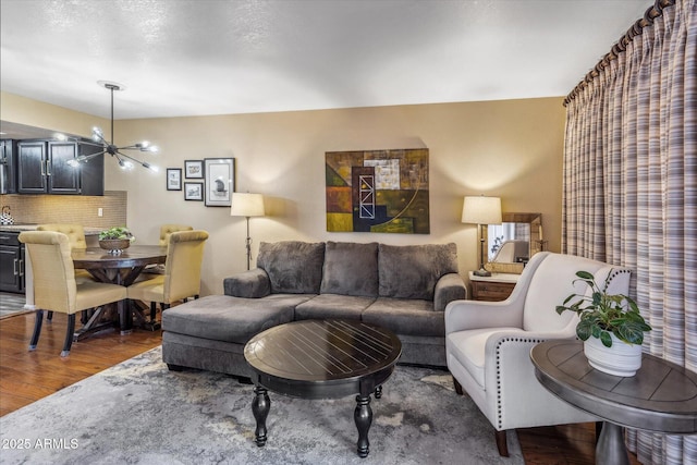 living room with dark wood-type flooring and a notable chandelier