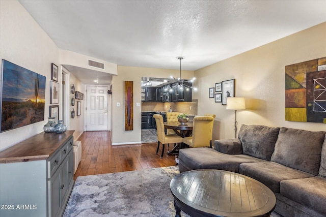 living room with an inviting chandelier and dark hardwood / wood-style floors