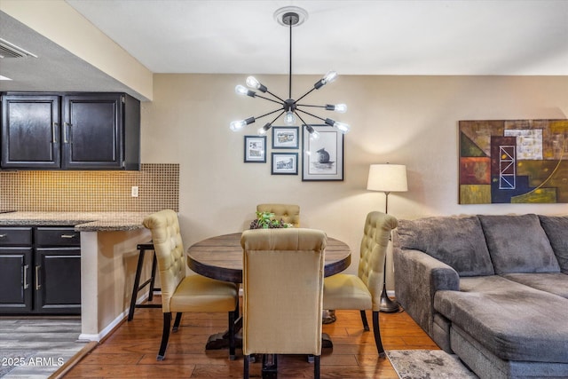 dining area with dark hardwood / wood-style flooring and a chandelier