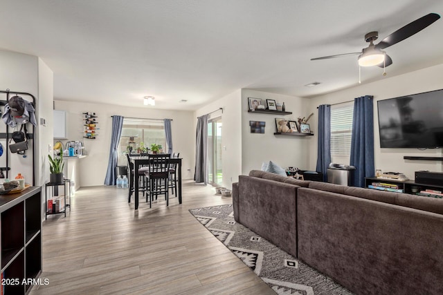 living room featuring ceiling fan, a healthy amount of sunlight, and light hardwood / wood-style flooring