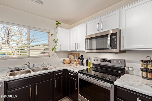 kitchen featuring light stone countertops, appliances with stainless steel finishes, sink, and white cabinets