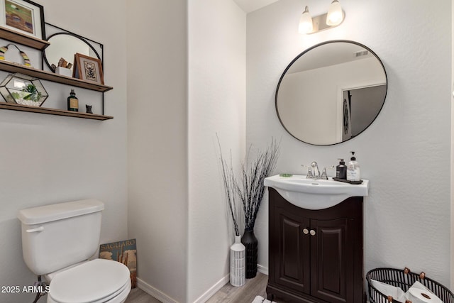 bathroom featuring vanity, hardwood / wood-style floors, and toilet