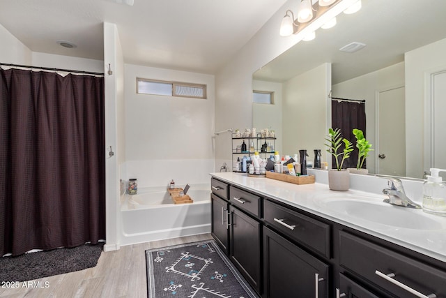 bathroom featuring vanity, hardwood / wood-style floors, and a tub